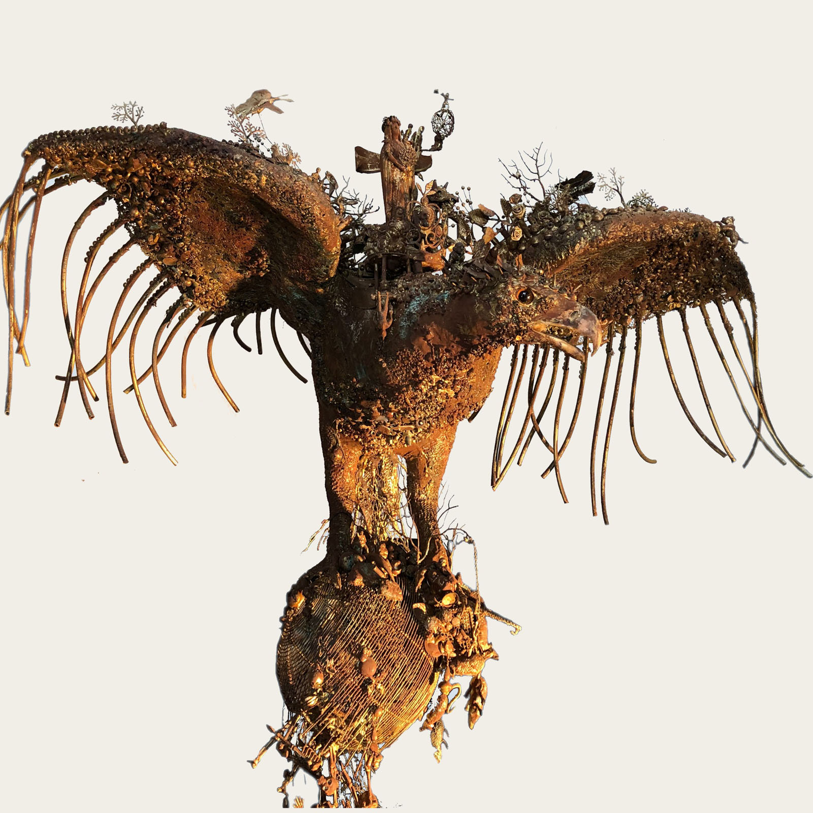 Sculpture dorée en forme d'oiseau aux ailes déployées, ornée de multiples objets et détails complexes — exposition Chimères